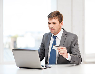 Image showing man with laptop and credit card in office