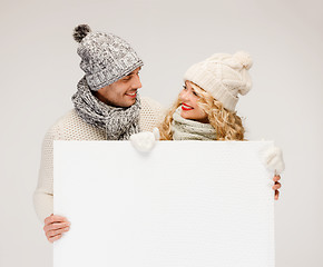 Image showing couple in winter clothes with blank white board