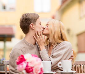 Image showing romantic happy couple kissing in the cafe