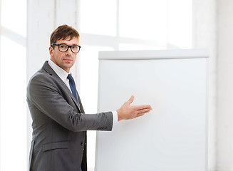 Image showing businessman pointing to flip board in office