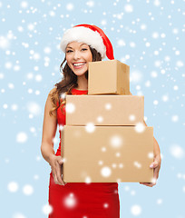 Image showing smiling woman in santa helper hat with parcels