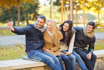 Image showing group of friends with photo camera in autumn park