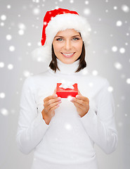 Image showing smiling woman in santa hat with small gift box