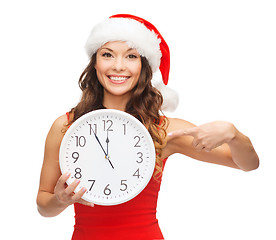 Image showing woman in santa helper hat with clock showing 12