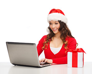 Image showing woman with gift box and laptop computer