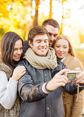 Image showing group of friends with photo camera in autumn park