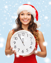 Image showing woman in santa helper hat with clock showing 12