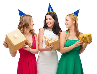 Image showing three smiling women in blue hats with gift boxes
