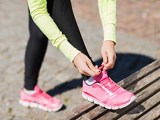 Image showing runner woman lacing trainers shoes