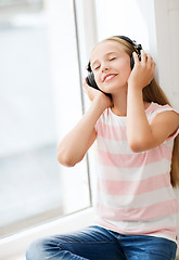 Image showing little girl with headphones at home