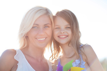Image showing happy mother and child girl with pinwheel toy