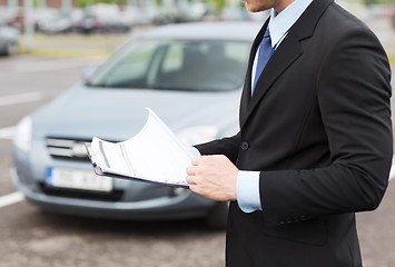 Image showing man with car documents outside