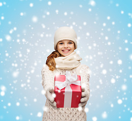 Image showing girl in hat, muffler and gloves with gift box