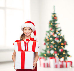 Image showing girl in santa helper hat with many gift boxes