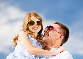 Image showing happy father and child in sunglasses over blue sky