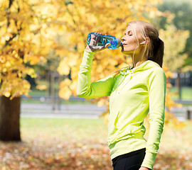 Image showing woman drinking water after doing sports outdoors