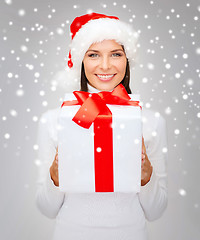 Image showing smiling woman in santa helper hat with gift box