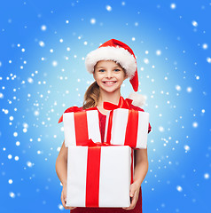 Image showing girl in santa helper hat with many gift boxes