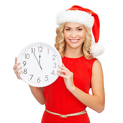 Image showing woman in santa helper hat with clock showing 12