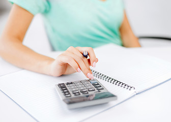 Image showing businesswoman working with calculator in office