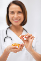 Image showing doctor holding bowl of capsules