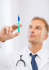 Image showing male doctor holding syringe with injection