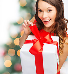 Image showing smiling woman in red dress with gift box