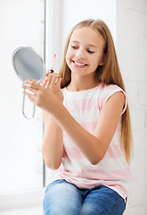 Image showing teenage girl with lip gloss and mirror