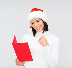 Image showing woman in santa helper hat with blank red postcard