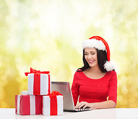 Image showing woman with gift boxes and laptop computer