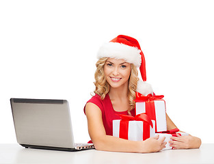 Image showing woman with gift boxes and laptop computer