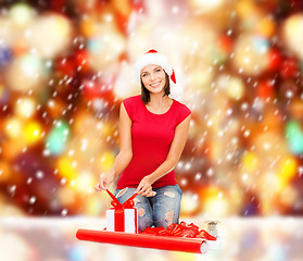 Image showing smiling woman in santa helper hat with gift box