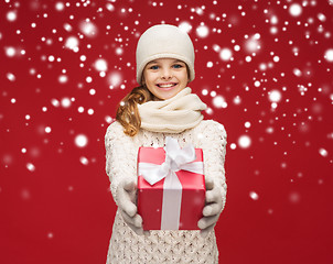 Image showing girl in hat, muffler and gloves with gift box