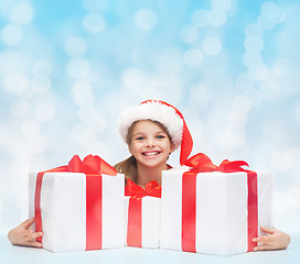 Image showing girl in santa helper hat with many gift boxes