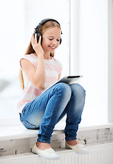 Image showing girl with tablet pc and headphones at home