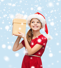 Image showing smiling girl in santa helper hat with gift box