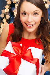 Image showing smiling woman in red dress with gift box