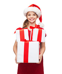 Image showing girl in santa helper hat with many gift boxes