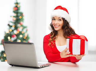 Image showing woman with gift box and laptop computer