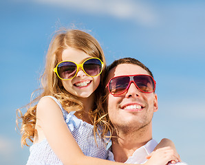 Image showing happy father and child in sunglasses over blue sky