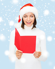 Image showing woman in santa helper hat with blank red postcard