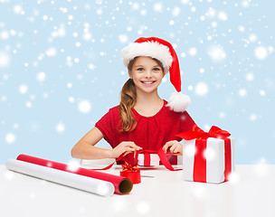 Image showing smiling girl in santa helper hat with gift box