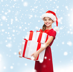 Image showing girl in santa helper hat with many gift boxes