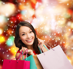 Image showing woman in red dress with shopping bags