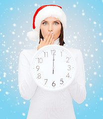 Image showing woman in santa helper hat with clock showing 12