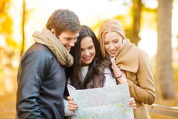 Image showing friends with tourist map in autumn park