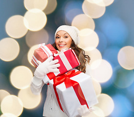 Image showing woman in sweater and hat with many gift boxes