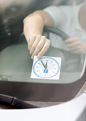 Image showing man placing parking clock on car dashboard