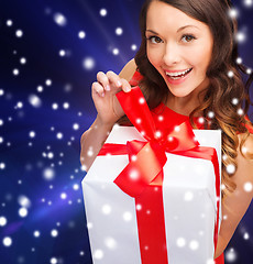 Image showing smiling woman in red dress with gift box