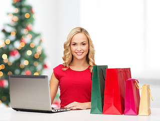 Image showing woman with shopping bags and laptop computer